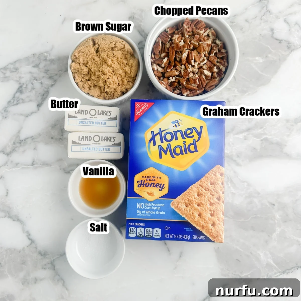 Various ingredients for pecan pie bark laid out: graham crackers, brown sugar, butter, pecans, vanilla extract, and salt.