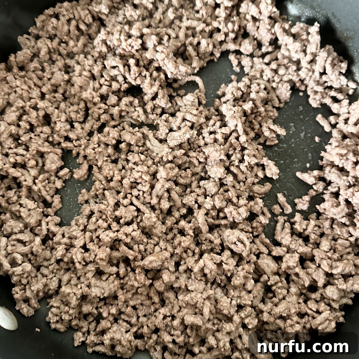 Savory Burger Dipping Sauce 4 Lean ground beef sizzling in a large skillet, expertly browned and broken into fine crumbles, ready for the next step in the dip recipe.