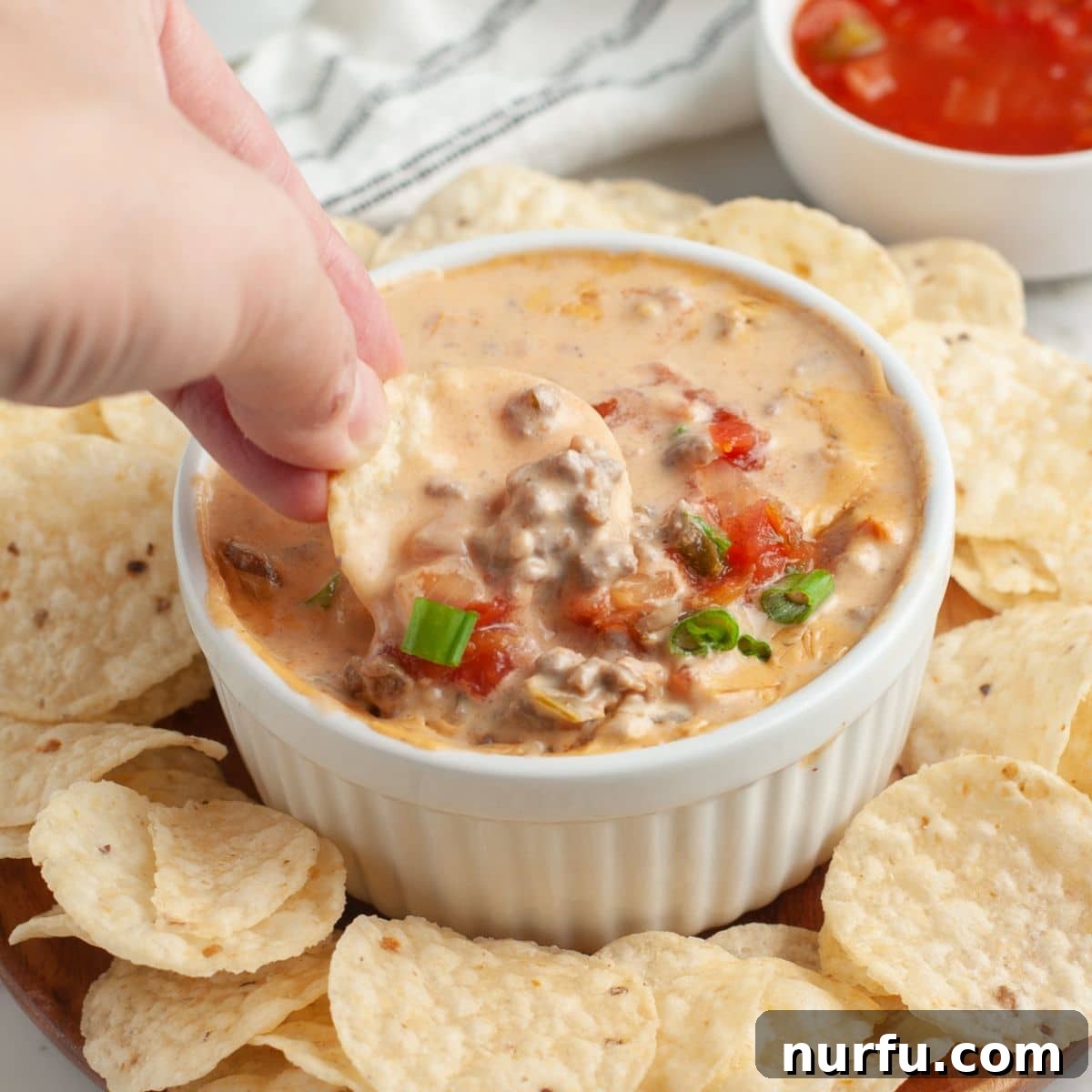 Savory Burger Dipping Sauce 6 A crisp tortilla chip perfectly loaded with a generous scoop of hot, creamy, and cheesy hamburger dip, ready to be enjoyed.