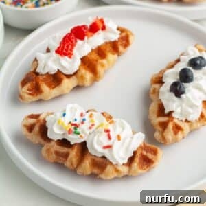 Three croffles on a plate topped with whipped cream.