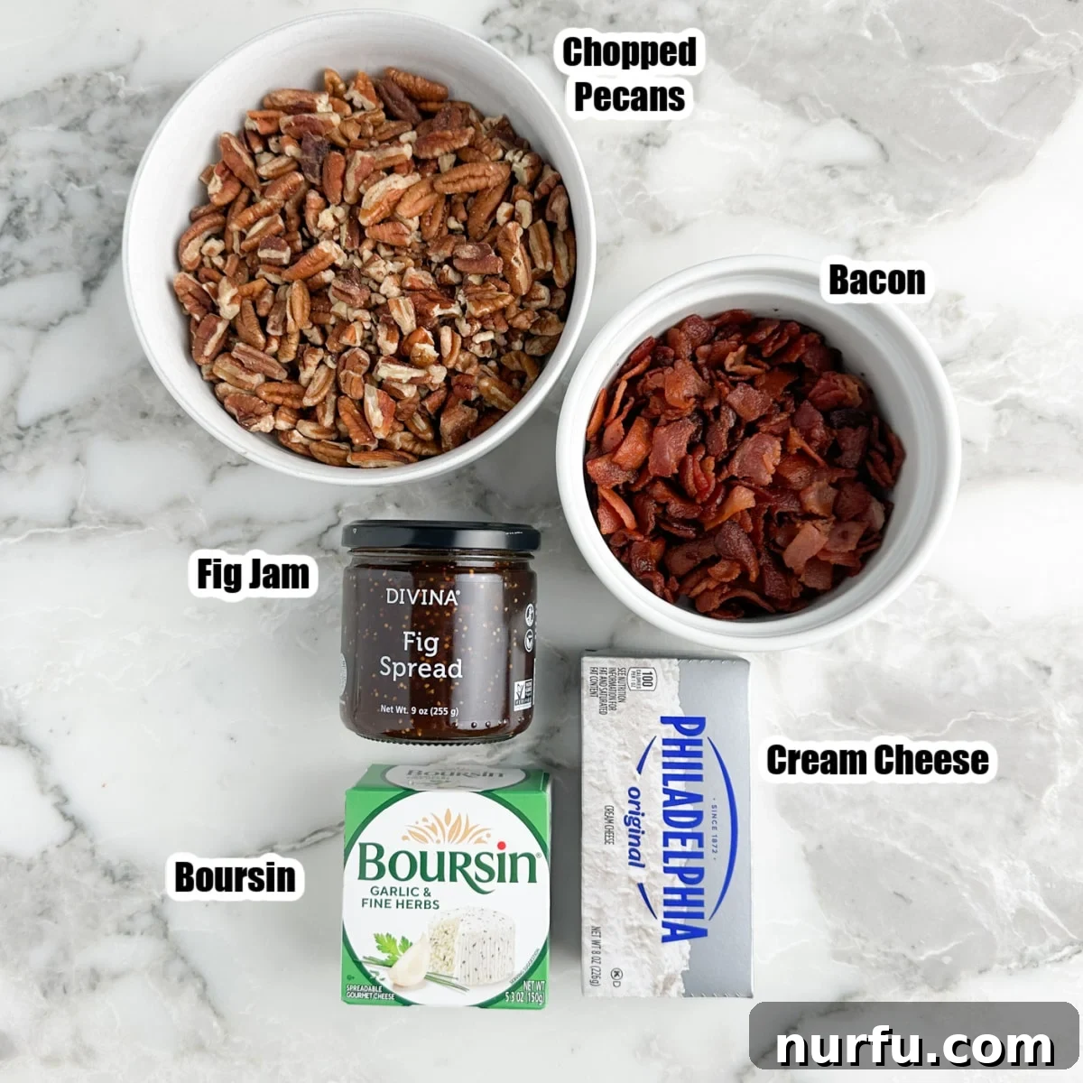 Fig & Bacon Boursin Bliss 3 A vibrant flat lay of all the essential ingredients: a block of cream cheese, a round of Boursin, a jar of fig jam, a bowl of crispy bacon bits, and a bowl of chopped pecans.