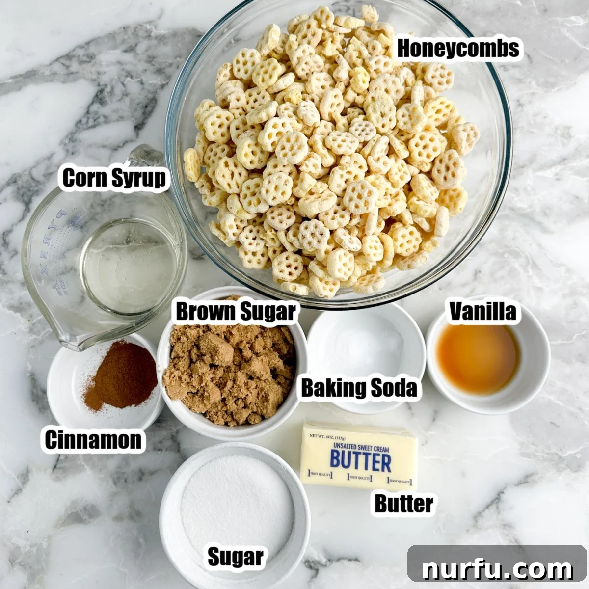 Churro Fiesta Mix 3 A collection of ingredients for churro snack mix: Honeycomb cereal, brown sugar, granulated sugar, unsalted butter, baking soda, and corn syrup, laid out on a clean surface.