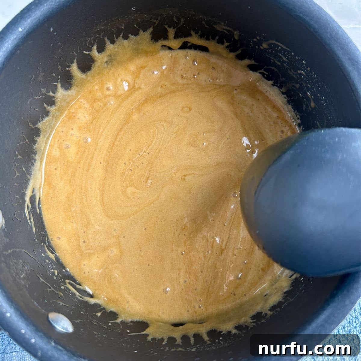 Churro Fiesta Mix 4 A saucepan filled with golden, bubbling caramel sauce, demonstrating the perfect consistency before mixing.