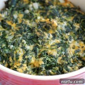 A casserole dish featuring creamy, cheesy baked spinach, golden and ready to serve.