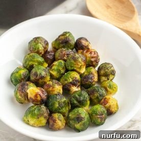 A bowl of perfectly roasted Brussel sprouts, slightly caramelized and tender-crisp.