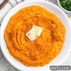 A bowl of exquisitely smooth and creamy whipped sweet potatoes, ready to be served.