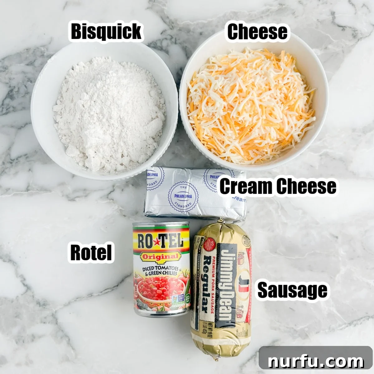 A collection of the fresh ingredients laid out: a bowl of Bisquick mix, a mound of shredded cheese, a block of softened cream cheese, a can of Rotel, and a package of raw breakfast sausage, ready for mixing.
