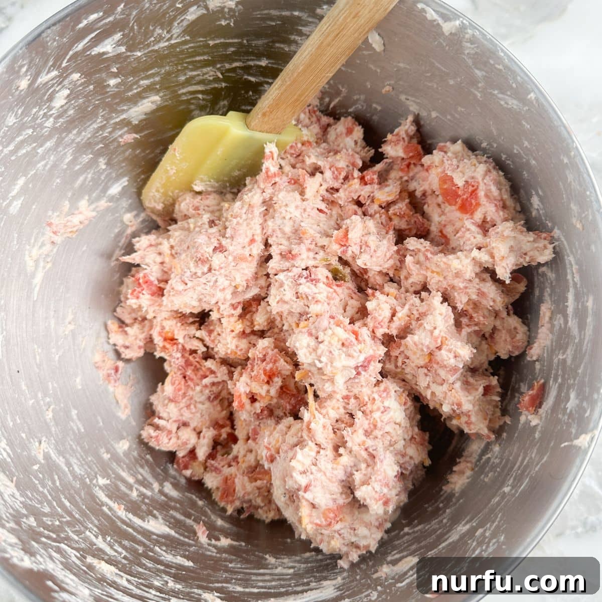 A large mixing bowl filled with the combined Rotel Cream Cheese Sausage Ball mixture, showcasing its consistent texture before rolling.
