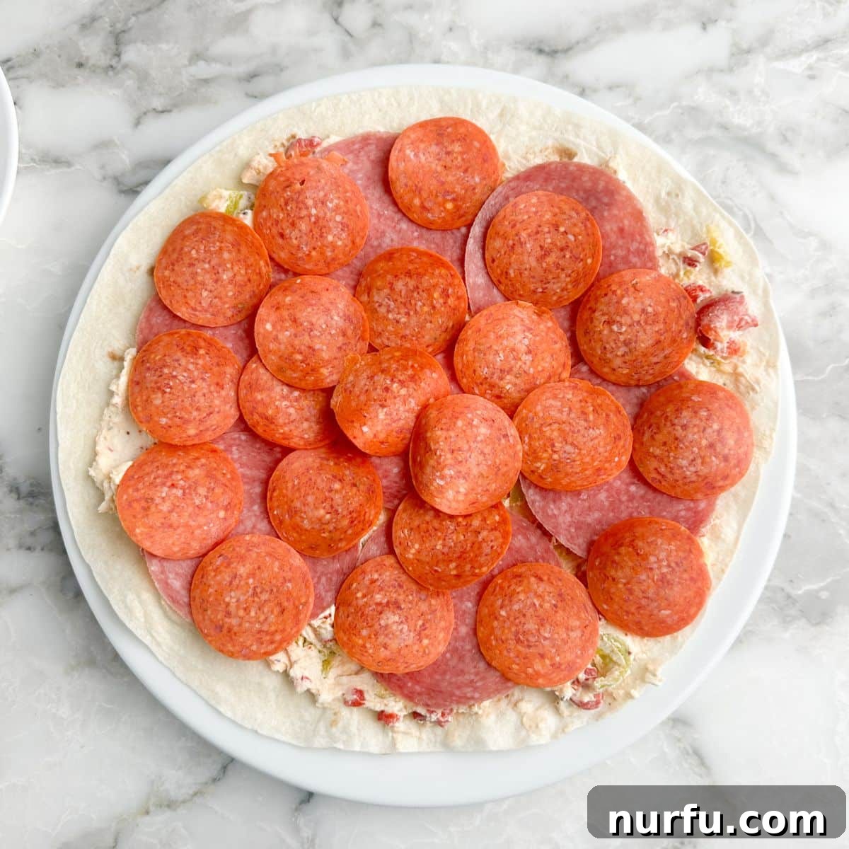 Italian Spiral Bites 6 A tortilla generously topped with the cream cheese spread, followed by layers of savory salami and spicy pepperoni.