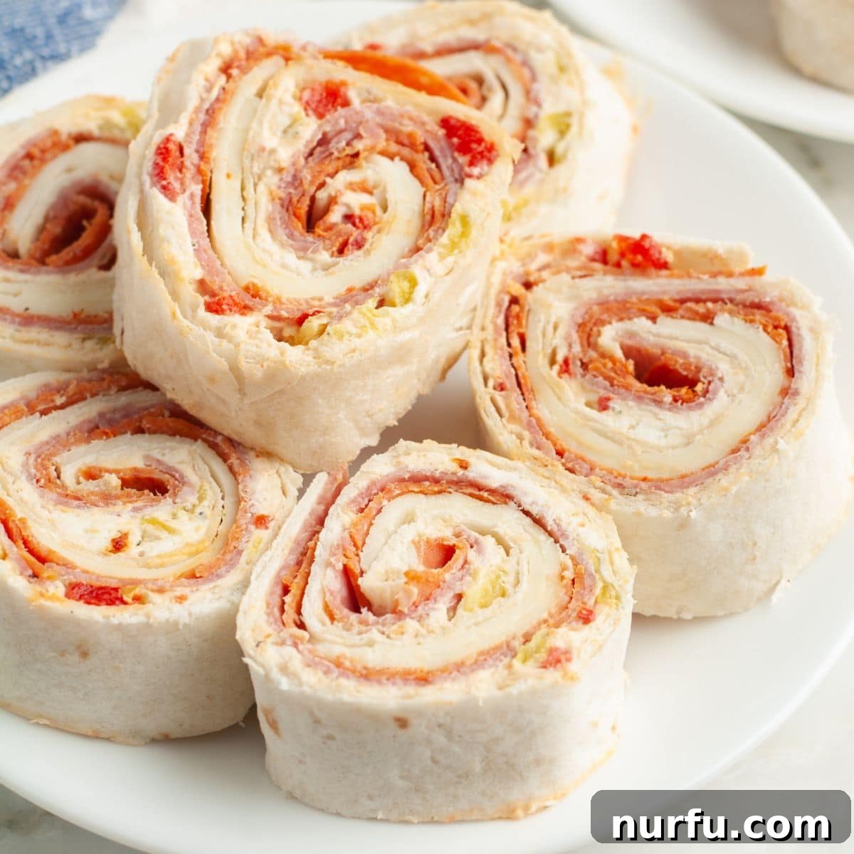 Italian Spiral Bites 9 An elegant platter of perfectly sliced Italian pinwheels, showcasing the beautiful layers of filling.
