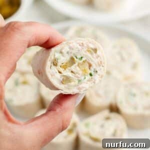 Creamy Dill Pickle Roll-Ups 9 Hand holding a pickle pinwheel.