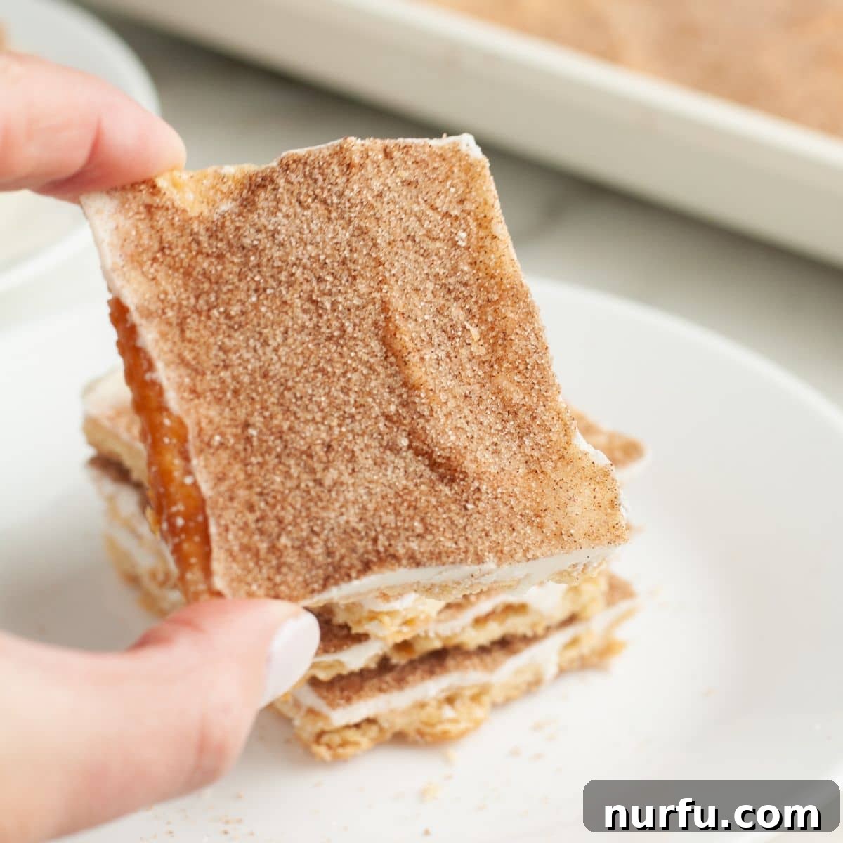 Cinnamon Caramel Saltines 10 A hand holding a piece of perfectly broken churro toffee.