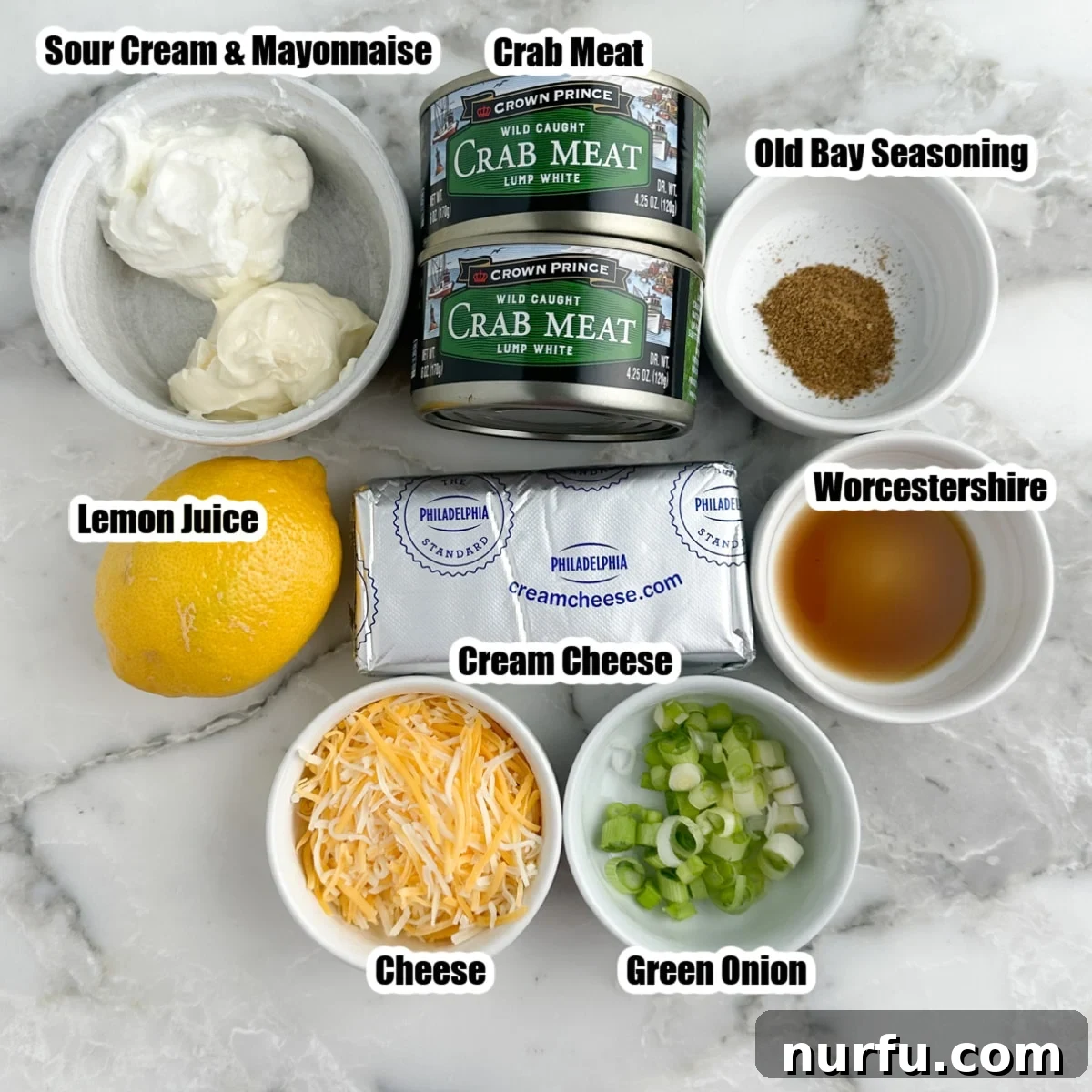 Chilled Crab Delight 3 Assortment of fresh and canned ingredients for cold crab dip: canned crab meat, whole lemon, shredded cheese, green onions, block of cream cheese, Old Bay seasoning, and a jar of mayonnaise.