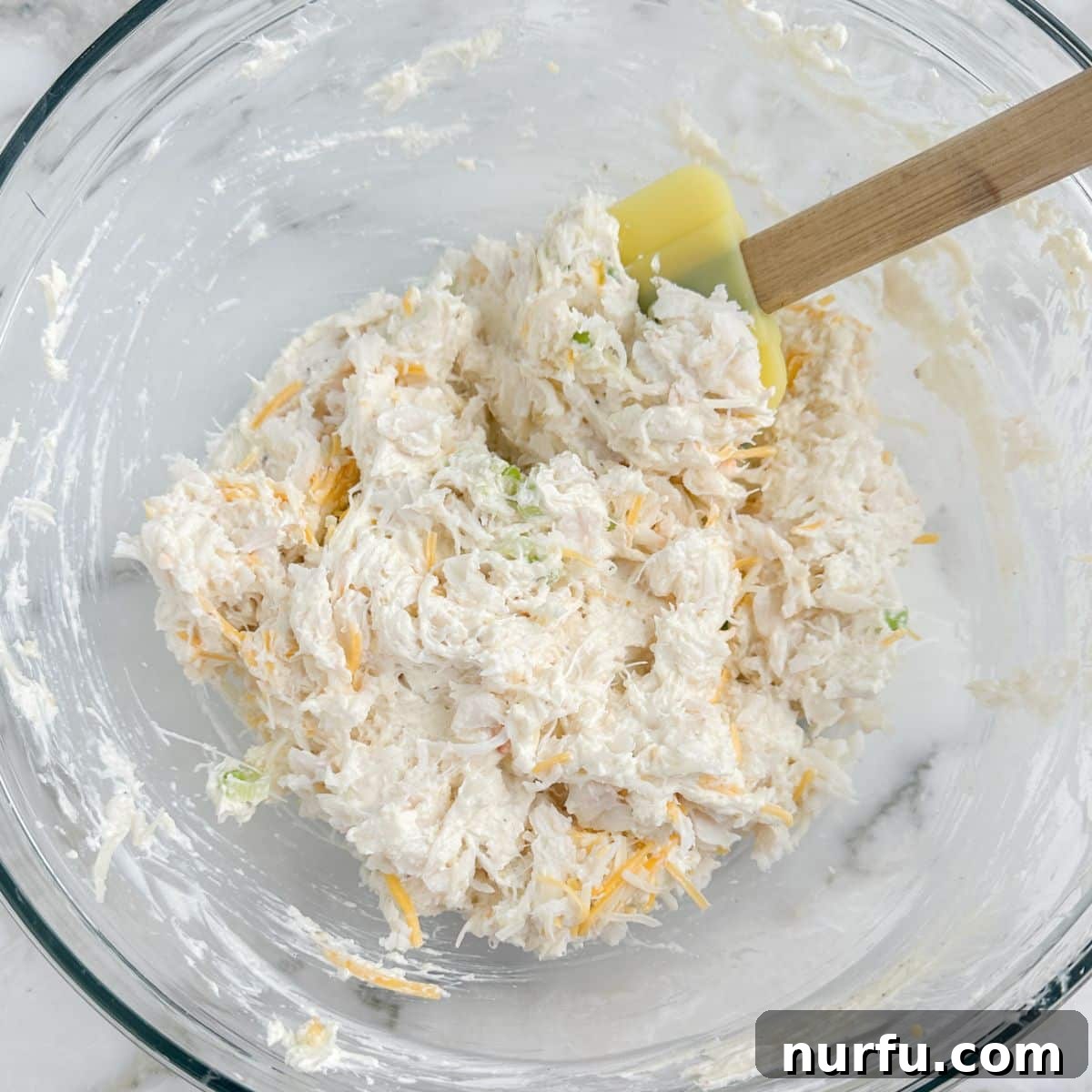 Chilled Crab Delight 7 Final bowl of perfectly mixed cold crab dip, with a spatula resting in it, ready to be served.