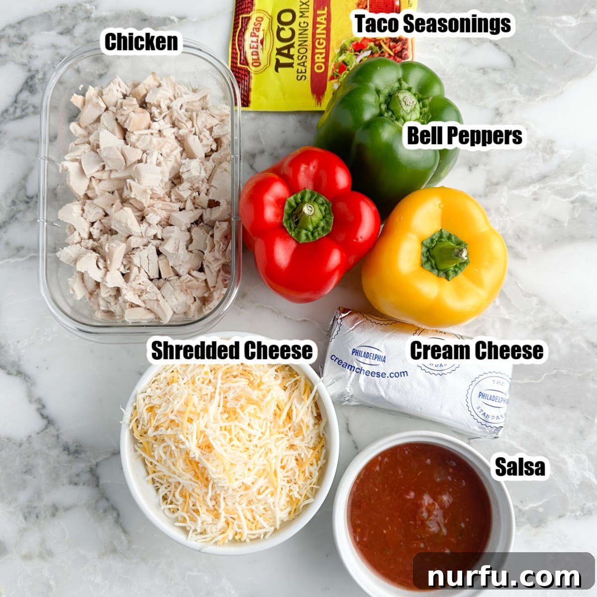 All the fresh ingredients for chicken stuffed bell peppers laid out: colorful bell peppers, cooked chicken, taco seasonings, shredded cheese, salsa, and softened cream cheese.