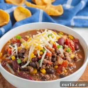 Southwestern Fiesta Soup 9 A steaming bowl of Santa Fe soup, richly colored with beans, corn, and ground beef, topped generously with melted cheese and fresh cilantro, ready to be enjoyed.