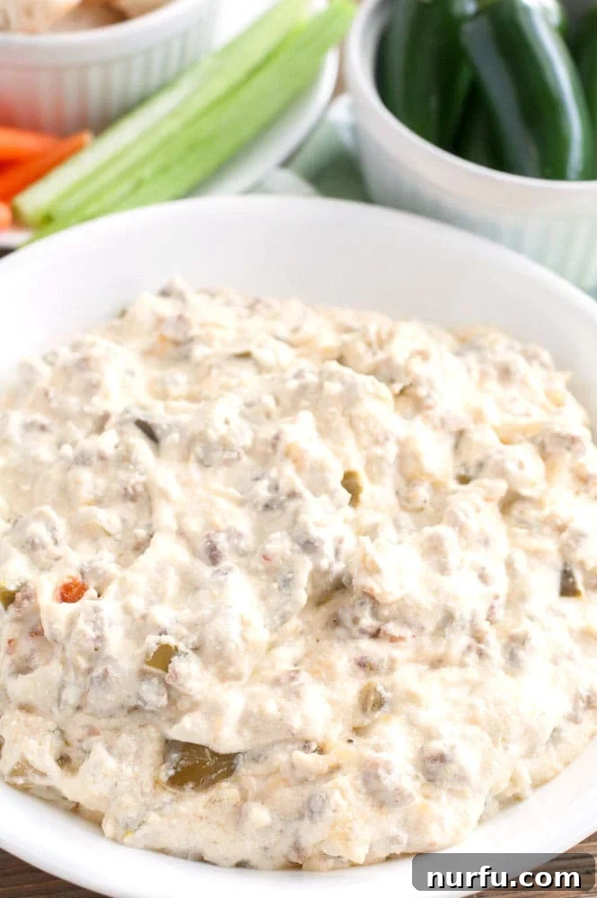 Delicious Sausage Jalapeño Popper Dip, ideal for parties Sausage Jalapeño Popper Dip in a serving bowl, showcasing its creamy texture with visible bits of sausage and jalapeños.