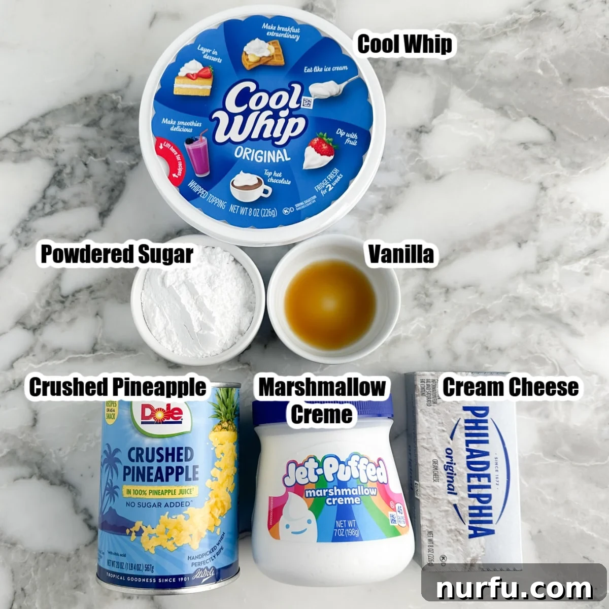 All the essential ingredients for making the delicious pineapple dip laid out on a clean surface, including a tub of Cool Whip, a can of crushed pineapple, a container of marshmallow creme, a block of cream cheese, and a small bowl of powdered sugar, ready for mixing.