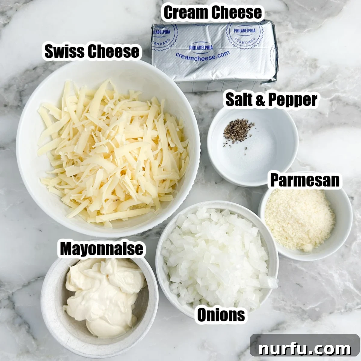 Irresistible Vidalia Onion Dip 3 A mixing bowl filled with the key ingredients for Vidalia onion dip: softened cream cheese, mayonnaise, shredded Swiss and Parmesan cheeses, and finely diced Vidalia onions.
