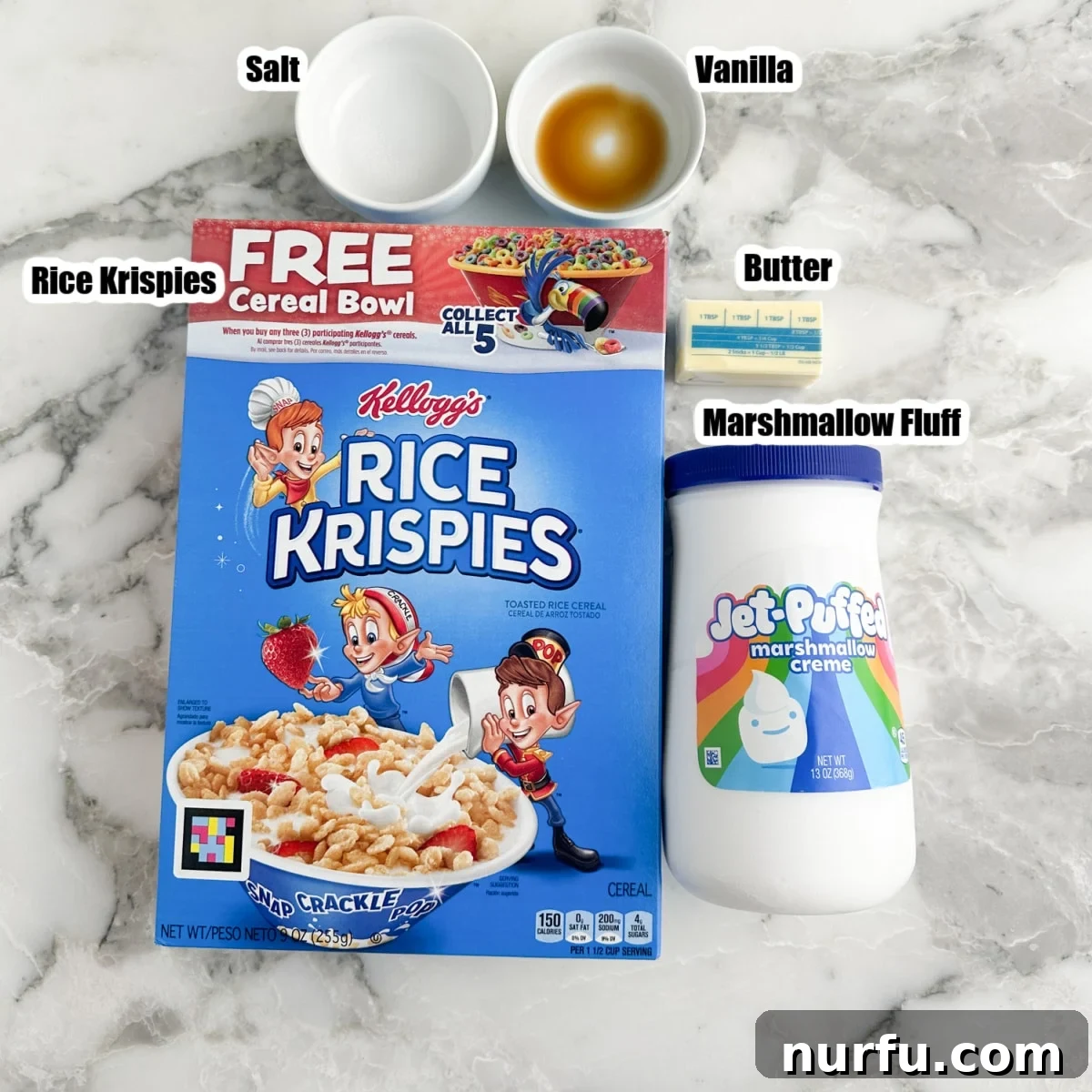Cloud Nine Krispie Treats 3 All the ingredients laid out on a table: a box of Rice Krispies cereal, a jar of marshmallow fluff, a stick of butter, a bottle of vanilla extract, and a small dish of salt.