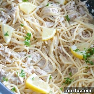 Slow cooker with pasta and lemon wedges.