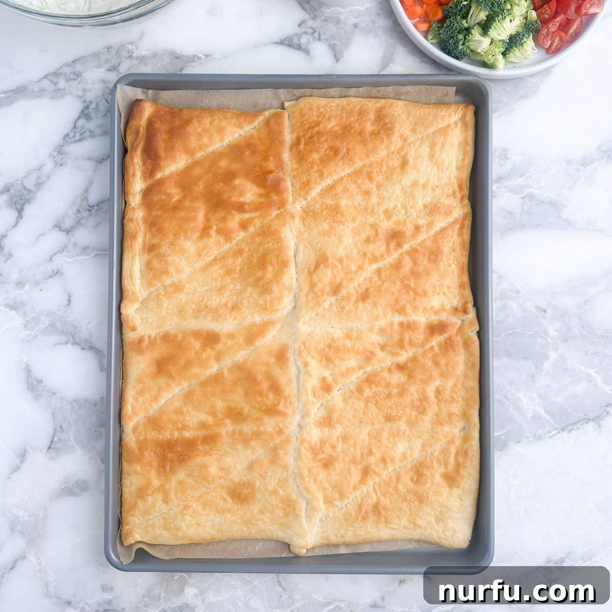Flaky Garden Veggie Bake 5 Baked crescent roll dough, lightly golden brown, resting on a baking sheet.