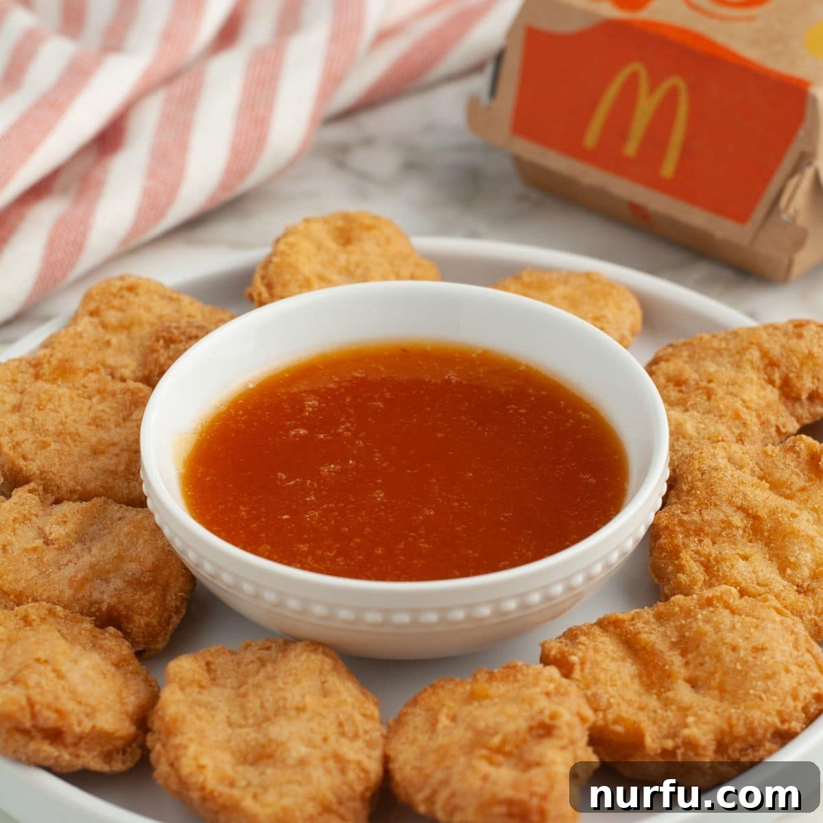 Perfect Homemade McDonalds Sweet and Sour Sauce 6 Plate with chicken nuggets and a bowl of sweet and sour sauce.