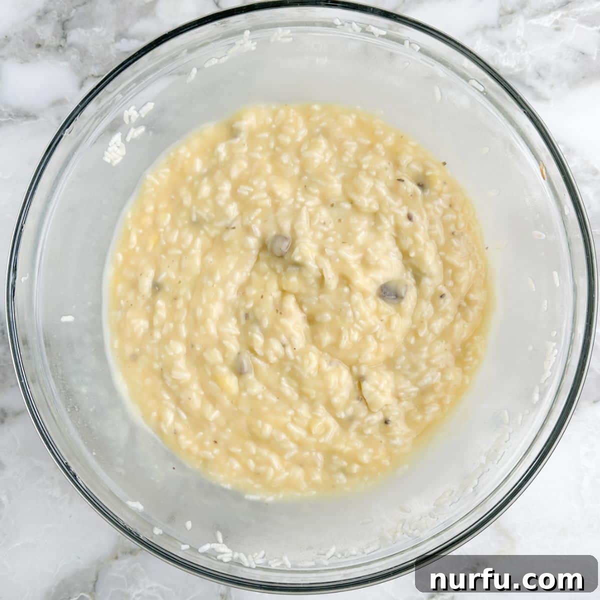 The Chicken That Time Forgot 5 A large mixing bowl filled with the creamy, uncooked mixture of Minute Rice, cream of chicken soup, cream of mushroom soup, and water, stirred together to form a uniform base.