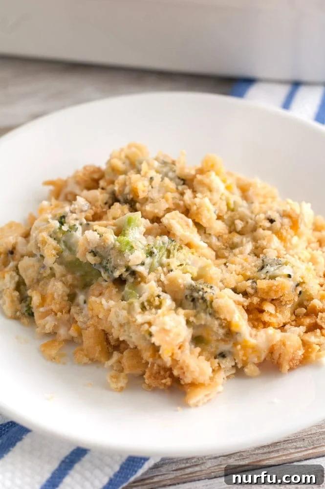 Broccoli Cheese Casserole with a Golden Crust A generous serving of golden-brown broccoli cheese casserole on a white plate with a fork, ready to be enjoyed.