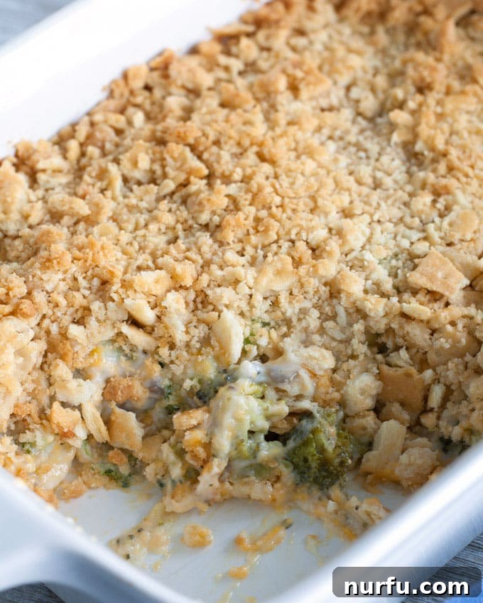 Freshly Baked Broccoli Cheese Casserole A freshly baked, golden-brown broccoli cheese casserole, bubbling around the edges, in a white ceramic baking dish.