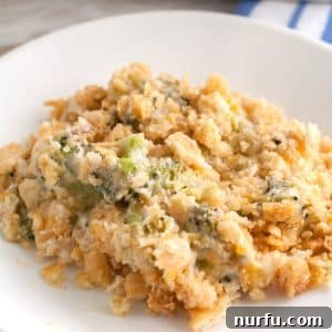 Plate with a generous serving of golden-brown broccoli cheese casserole, garnished with fresh parsley.