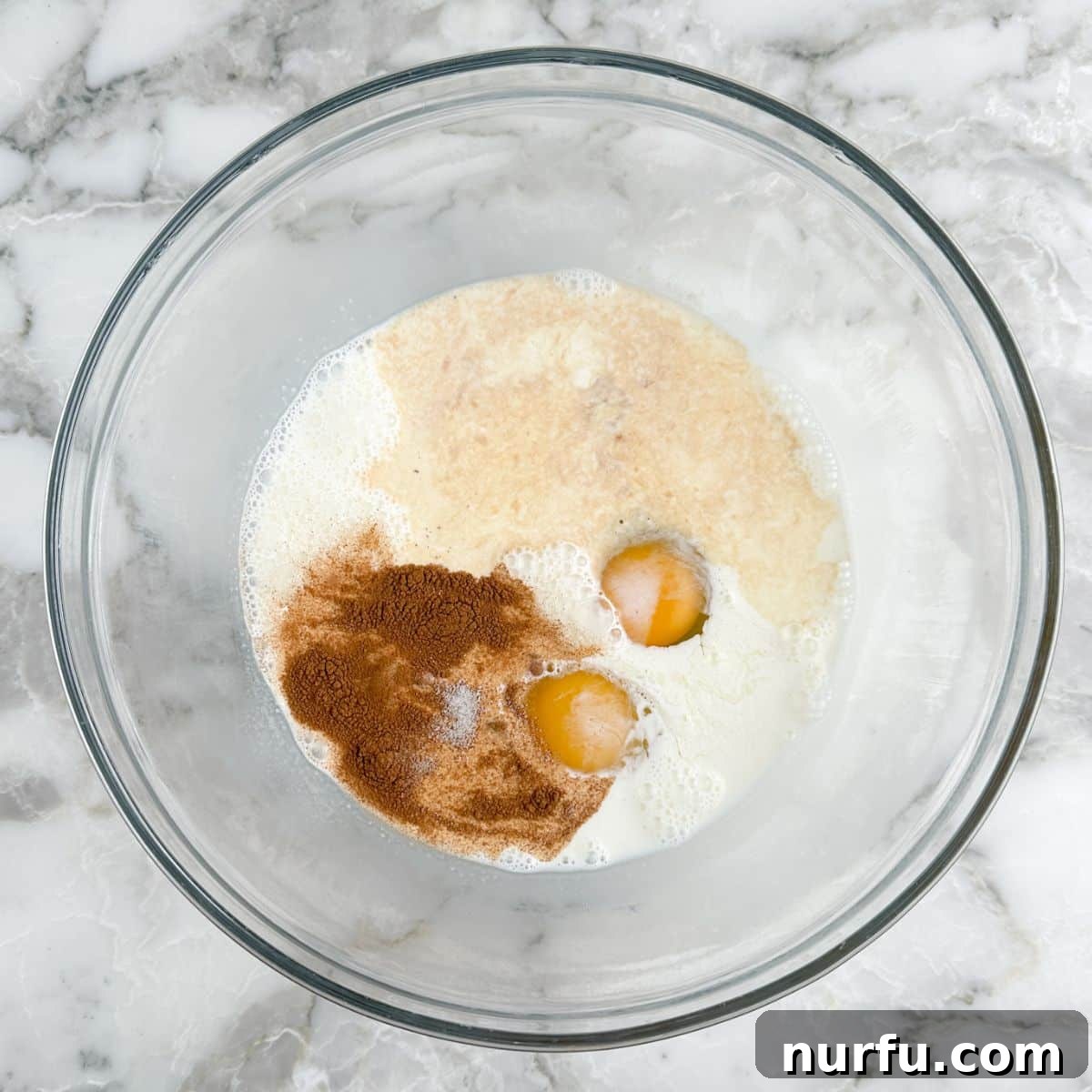 Pâtisserie French Toast 4 A large mixing bowl containing whisked eggs, half and half, cinnamon, sugar, and vanilla extract.