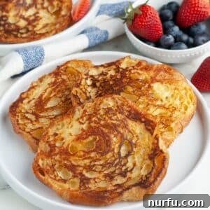 Plate of French toast with a bowl of berries.