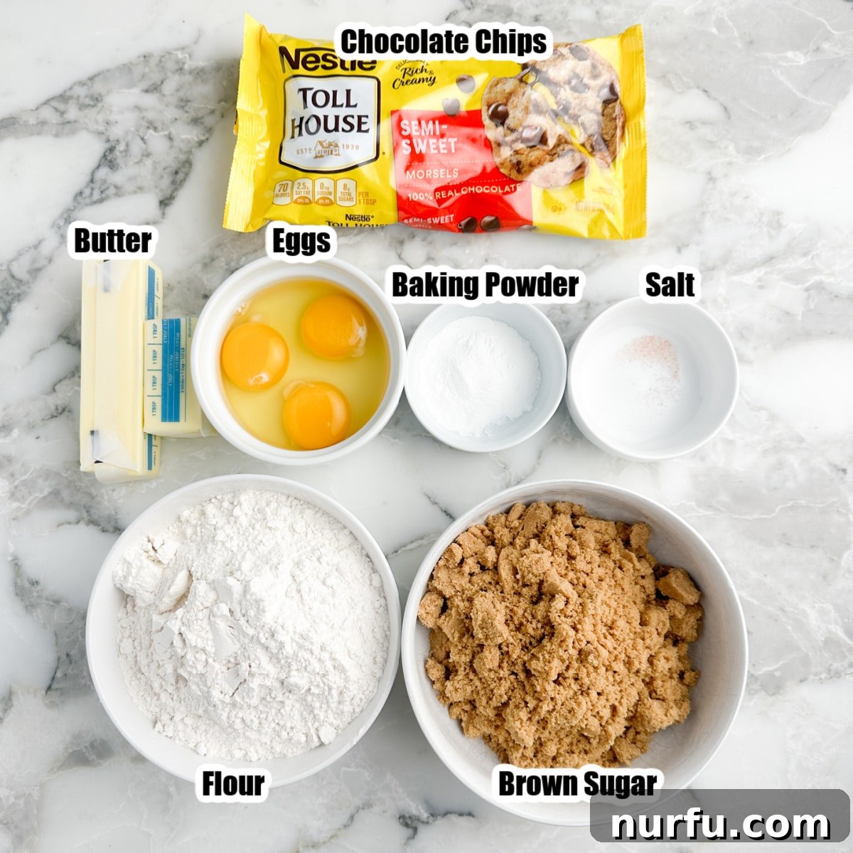 Gooey Brown Sugar Congo Bars 3 A collection of ingredients laid out: a bag of chocolate chips, a bowl of brown sugar, a bowl of flour, sticks of butter, eggs, and a container of baking powder.
