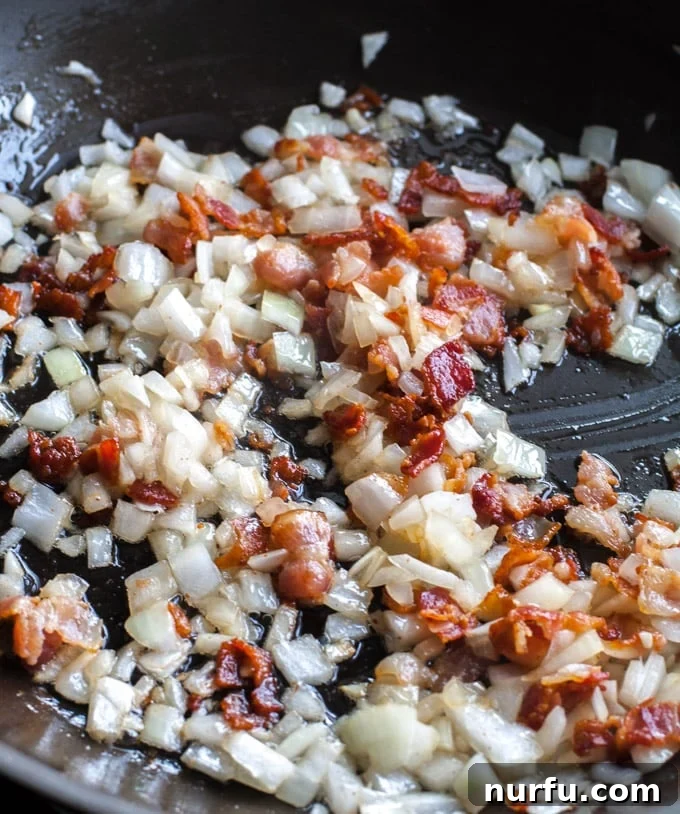Diced bacon and onion sizzling in a skillet, the start of a delicious Charro Bean recipe.