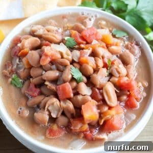 A bowl of Charro Beans garnished with fresh cilantro.