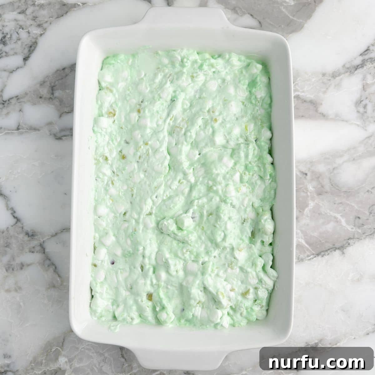 Sea Mist Salad 7 A glass 9x13 baking dish filled with the fully prepared sea foam salad, smoothed evenly across the surface.