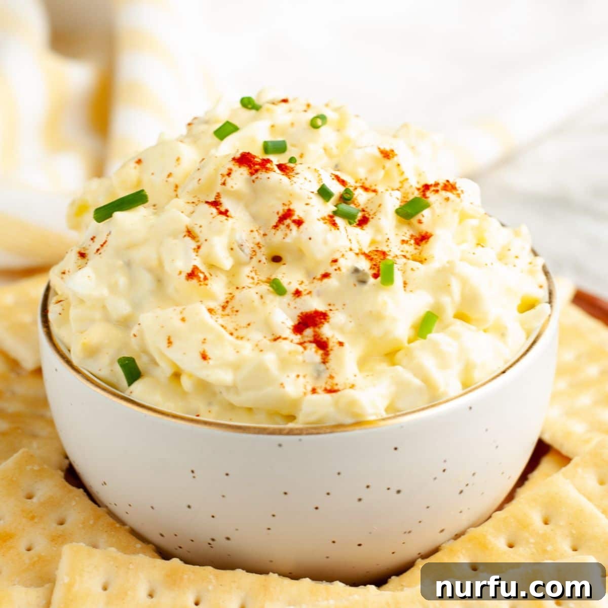 Savory Whipped Egg Dip 6 A vibrant bowl of deviled egg dip, generously garnished with a sprinkle of paprika and fresh green herbs, ready to be enjoyed as a delicious and easy appetizer.