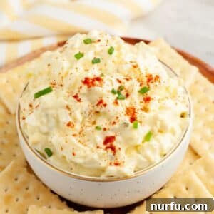 Bowl of deviled egg dip surrounded by crackers.