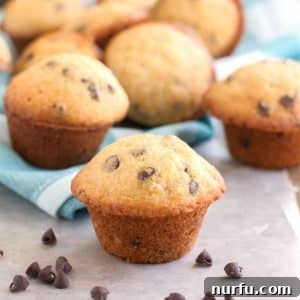 Golden mini chocolate chip muffins on a wooden table.