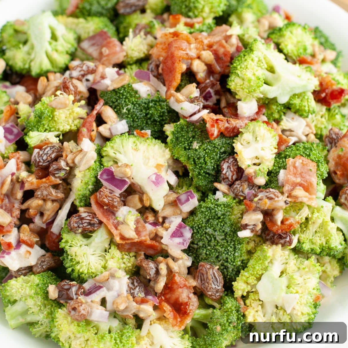 Vibrant Broccoli Raisin Bliss 6 A close-up shot of a broccoli raisin salad in a serving bowl, showcasing its fresh and colorful ingredients.