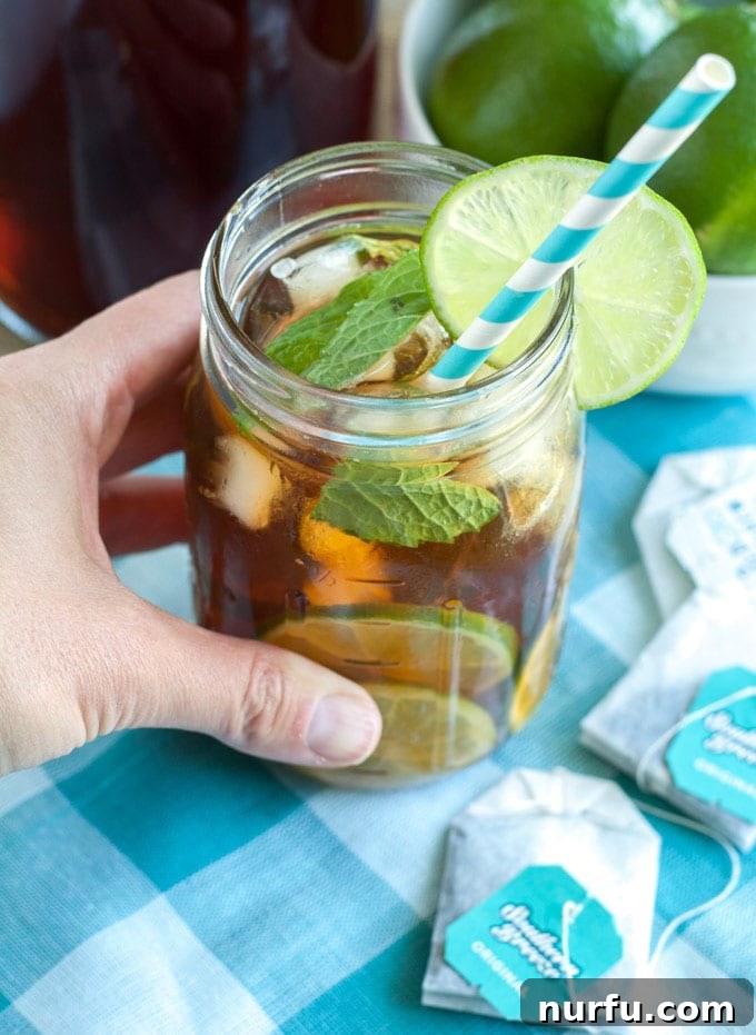 Mojito Sweet Tea Twist 5 Two glasses of Mojito Sweet Tea garnished with lime and mint on a wooden table