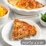 A perfectly sliced piece of Bisquick Cheeseburger Pie on a plate, revealing its cheesy, beefy layers.