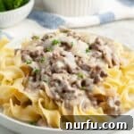 Plate of tender egg noodles topped with creamy hamburger stroganoff.