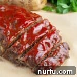 A perfectly cooked one-pound meatloaf, glistening with its savory sauce topping.