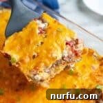 A spatula serving a piece of golden-brown cattle drive casserole, showing its hearty layers.