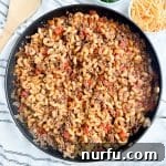 Skillet filled with comforting American Goulash, featuring ground beef, tomatoes, and elbow macaroni.