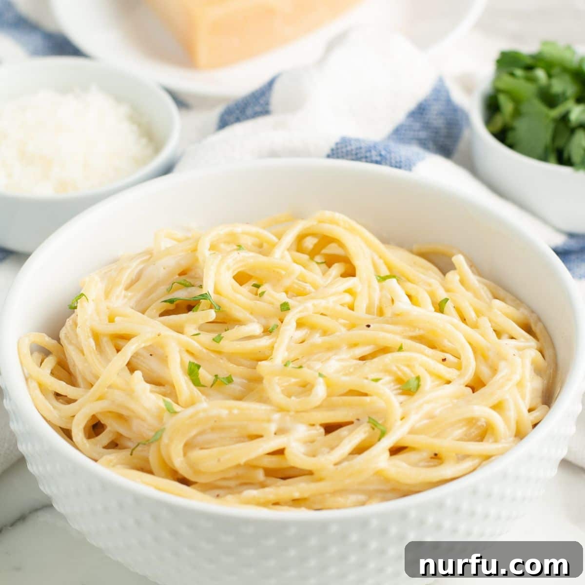 Creamy Parmesan Alfredo Spaghetti 8 A close-up shot of a fork twirled with creamy Spaghetti Alfredo, showing the rich sauce clinging to the pasta, ready to be eaten.