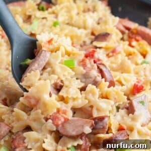 Hearty Kielbasa Pasta 8 Spoon scooping kielbasa pasta.