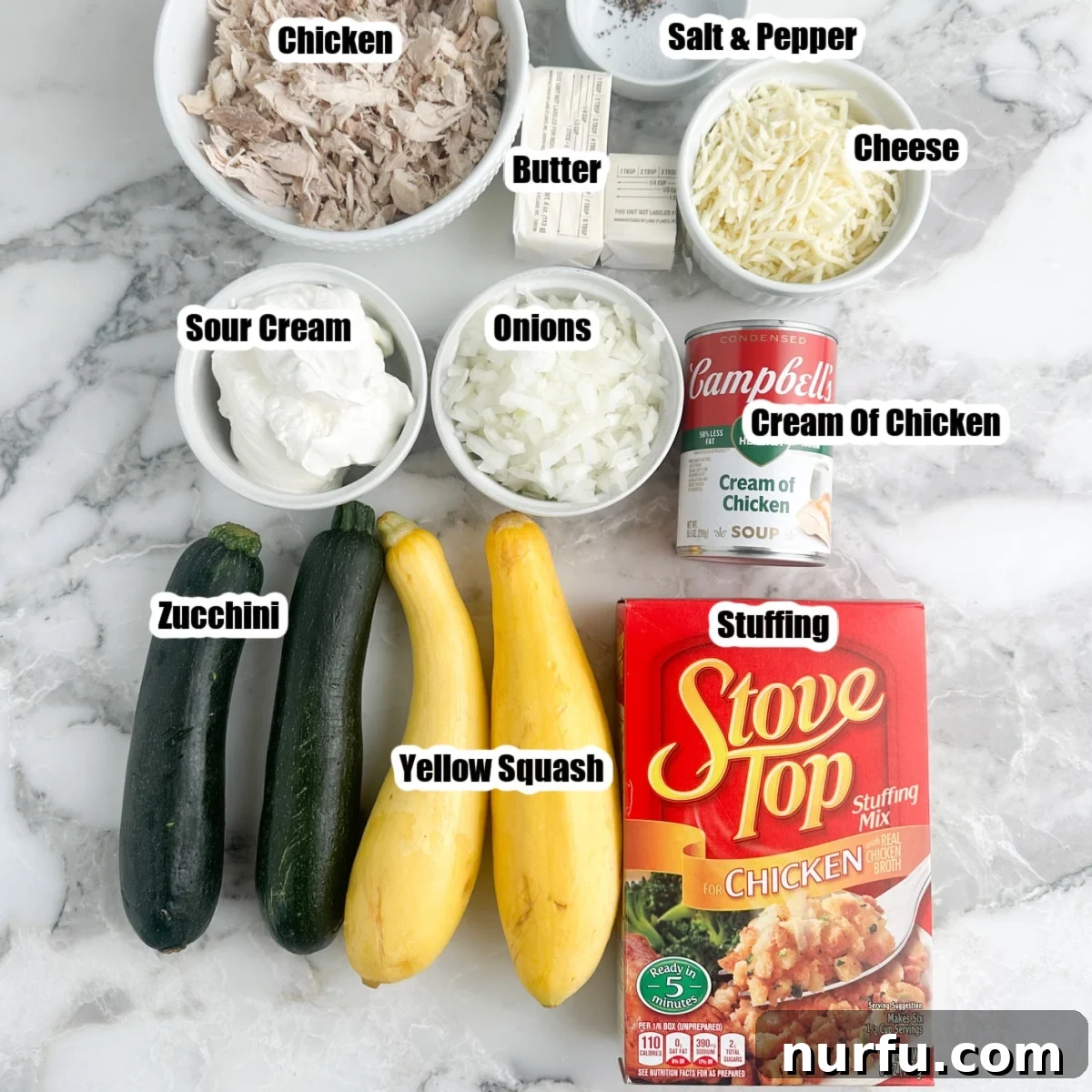 Comforting Chicken Zucchini Bake 3 A vibrant flat lay of all the fresh ingredients and pantry staples required for the chicken zucchini squash casserole, including sliced zucchini, golden yellow squash, a box of seasoned stuffing mix, shredded cooked chicken, a block of cheese, diced onions, a stick of butter, a tub of sour cream, and various seasonings, all neatly arranged on a kitchen counter.